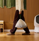 Petlibro PETLIBRO cat pet litter box scene, person carrying used litter bag; automatic feeder and fountain not shown
