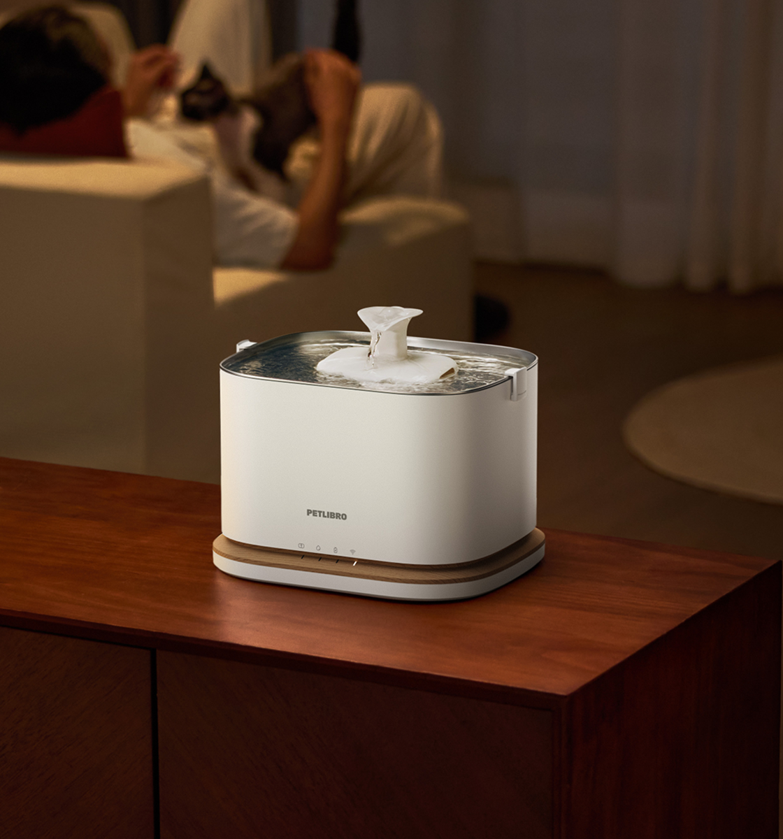 Petlibro PETLIBRO fontaine à eau blanche pour animal de compagnie; chat en arrière-plan, mention distributeur automatique de nourriture et bac à litière